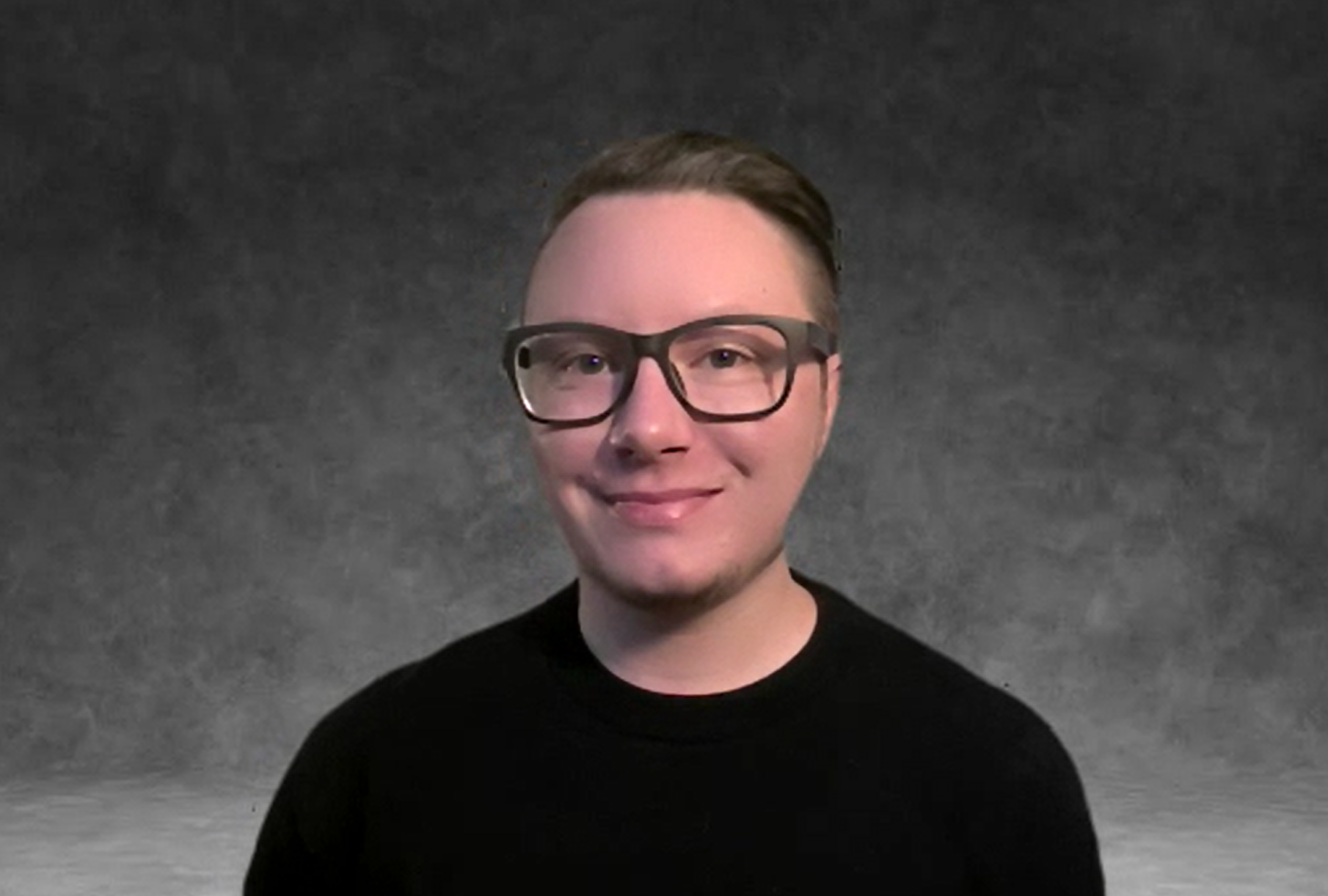 White man with glasses and short hair swept back wearing a black sweater